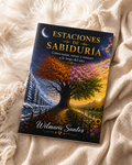 The book 'Estaciones de Sabiduría' by Wilmaris Santos is displayed on a soft, beige knitted blanket. The cover features a highly detailed, colorful illustration of a tree with autumn and spring foliage, set against a sunset sky with a crescent moon.
