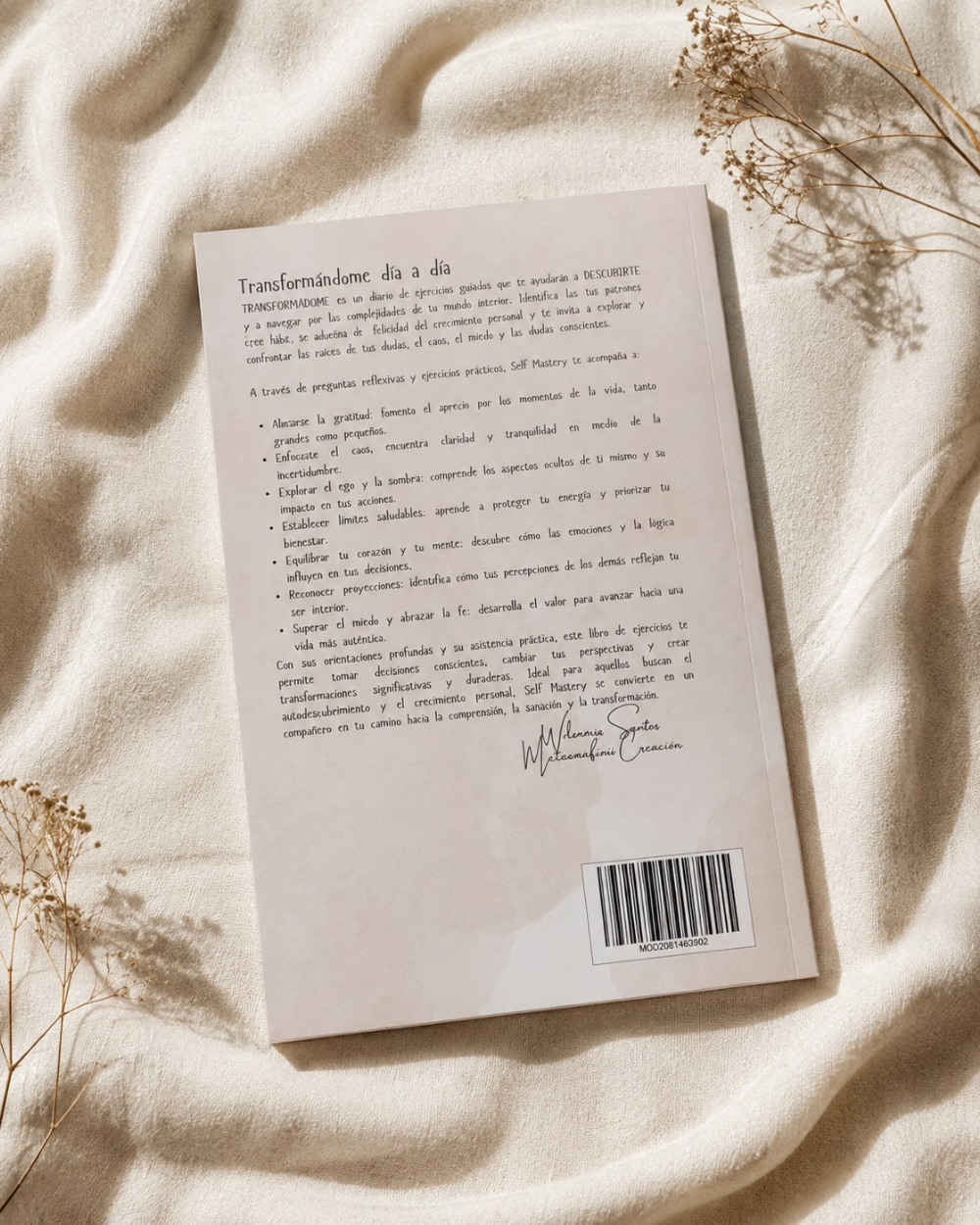The back cover of Transformandome by WIlmaris Santos, in Catalan, displayed on a textured beige fabric background with dried floral elements.
