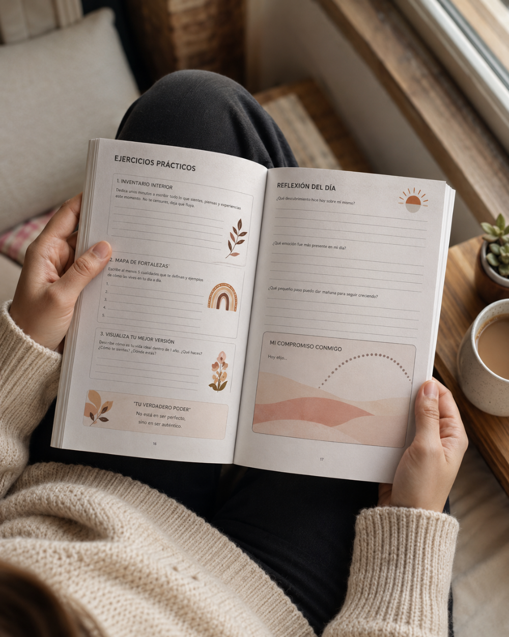 A person in a beige knit sweater holds an open Spanish-language workbook or journal  known to be Transformandome by wilmaris Santos on a wooden table near a window, with a cup of coffee and a small plant nearby.