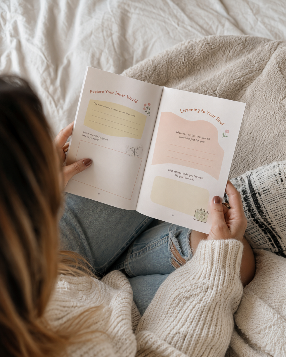 A person lying on a bed under a beige blanket, holding Becoming by Wilmaris Santos, with reflective prompts like 'Explore Your Inner World' and 'Listening to Your Self'